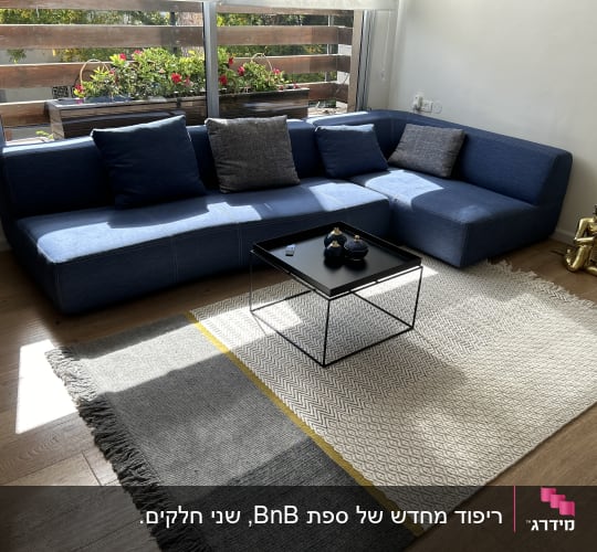 ספה פינתית מרופדת בבד כחול עם כריות נוי בסלון מודרני